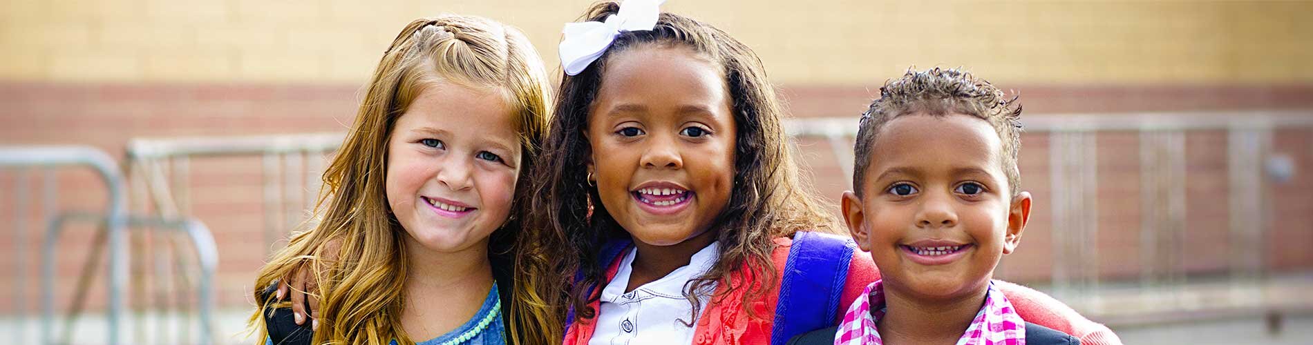 Three children pose for a group photo.